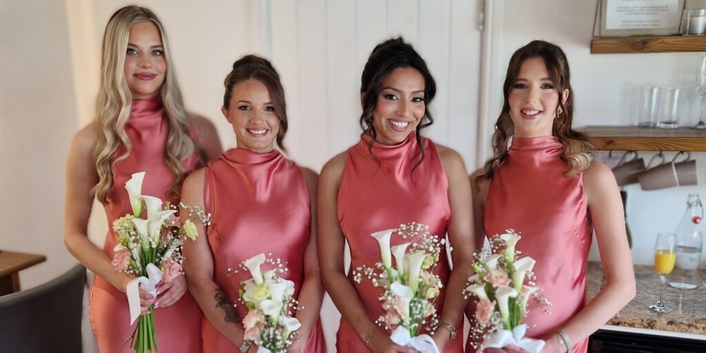 Beautiful bridal party with natural glowing wedding makeup and white bouquet.