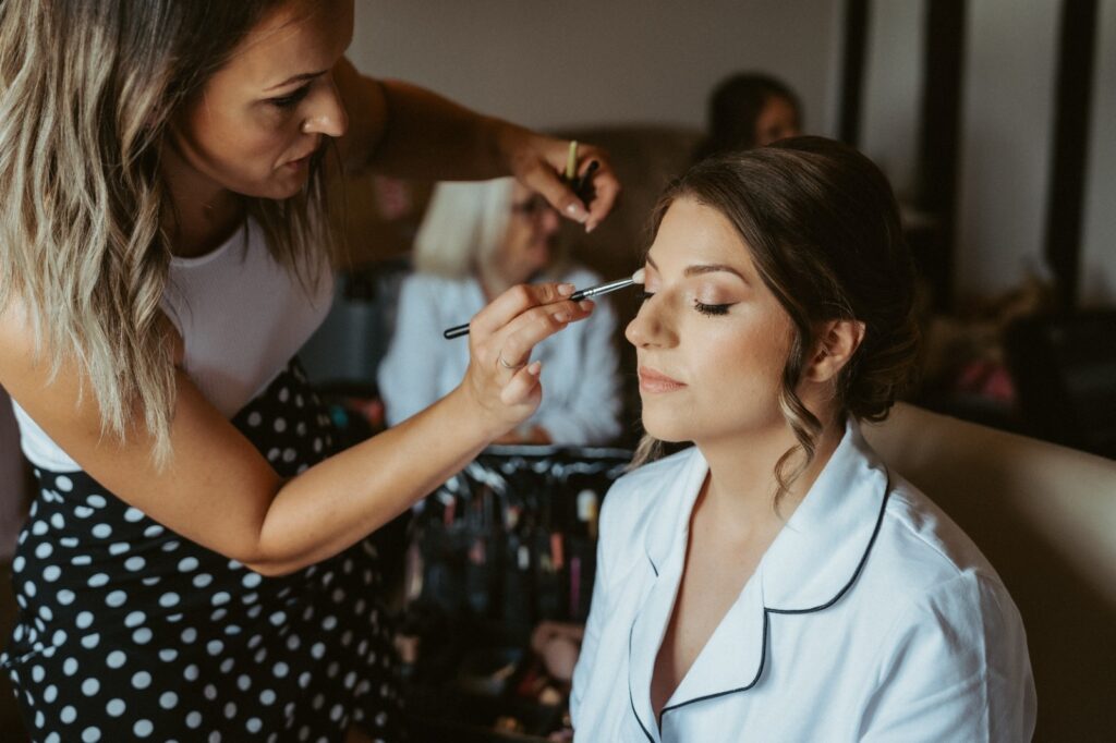 Multi award winning Essex bridal makeup artist Lynsey applying makeup to a bride on her wedding day.